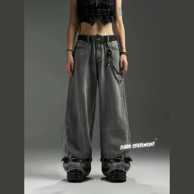 A pair of wide-leg denim jeans with a belt design at the bottom, featuring a mix of blue and green shades, and embellished with metal details and a chain.