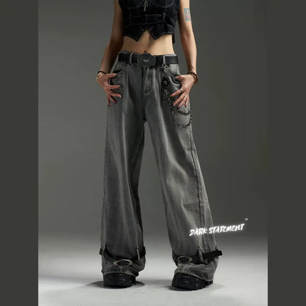 A pair of wide-leg denim jeans with a belt design at the bottom, featuring a mix of blue and green shades, and embellished with metal details and a chain.