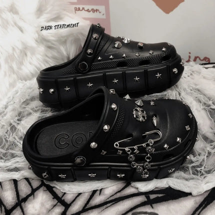 Black platform with rivets clogs on a white background with 'Dark Statement' brand.