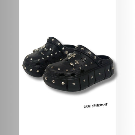Black platform with rivets clogs on a white background with 'Dark Statement' brand.