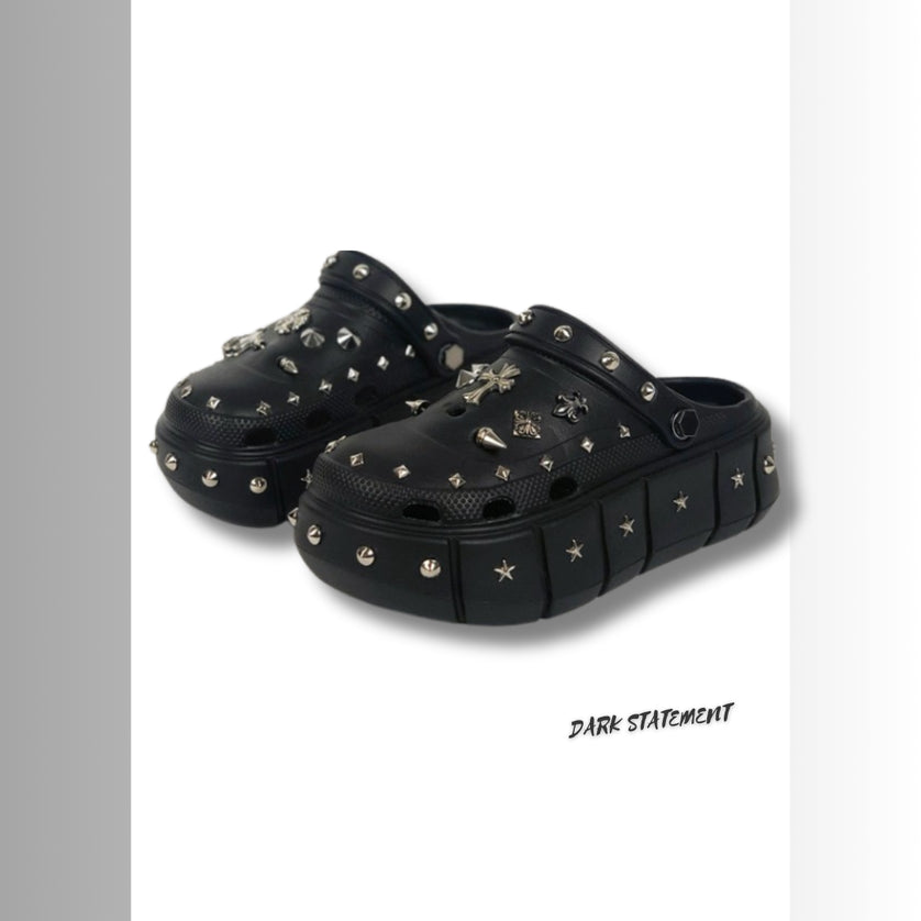 Black platform with rivets clogs on a white background with 'Dark Statement' brand.